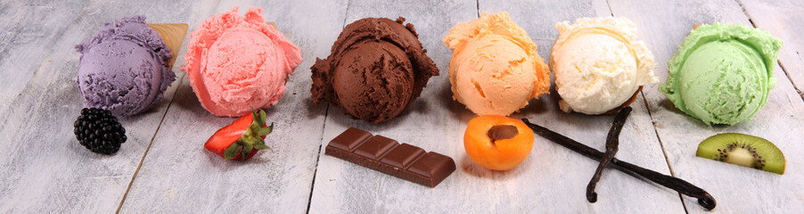 ice cream scoops of different colors and flavours with berries, nuts and fruits decoration on white...
