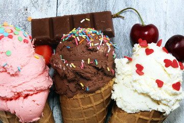 ice cream scoops of different colors and flavours with berries, sprinkles and fruits decoration on...