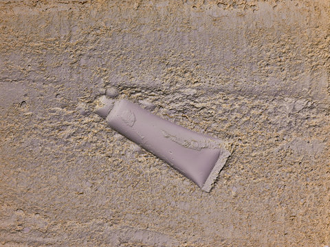 biodegradable single use Plastic cosmetic tube sunk in ground, pollution of the earth, environmental issues