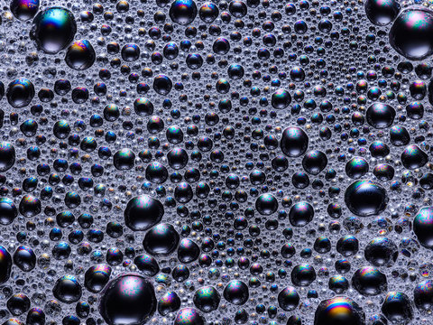Iridescent soap bubbles on black surface