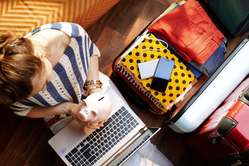 woman holding piggy bank planning low cost summer holiday