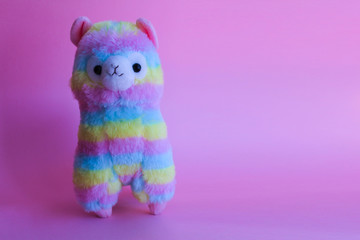 colorful lamp - children's toy, souvenir. beautiful rainbow colors. on a pink background. place for text.