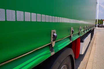 Semi-trailer with covered tarpaulin before unloading. Transport and unloading.