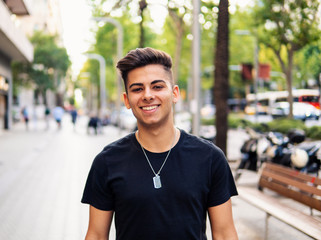 Young fashionable handsome man on the street of modern city. He looks happy