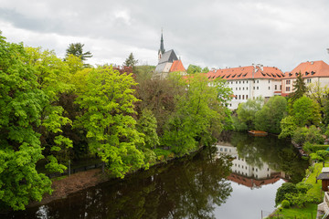 Fototapeta premium View of the Vltava River flowing through the town of Cesky Krumlov with the famous Cesky Krumlov Castle, Church of the World Heritage Site.