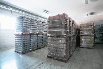 Interior of hangar or warehouse with rows of pallets with plastic bottles. Goods for logistic shipment and retail