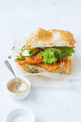 Sanwich with fried chicken on chiabatta with tomatoes, cheddar cheese, cucumber, onion, salad and microgreens