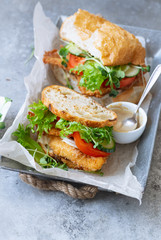 Sanwich with fried chicken on chiabatta with tomatoes, cheddar cheese, cucumber, onion, salad and...
