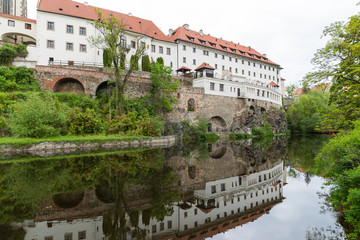 Obraz premium View of the Vltava River and the Church with the Reflection of the Cesky Krumlov River with the Famous Cesky Krumlov Castle, the UNESCO World Heritage Site