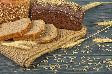 Rye bread and ears of rye on wooden table