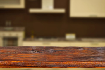 A wooden board on the background of the kitchen. An empty product board. Sharpness in the foreground. Empty space for goods.