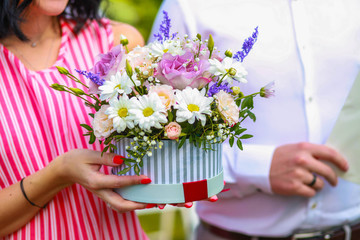 beautiful wedding bouquet in a basket in the hands of the guests at the wedding