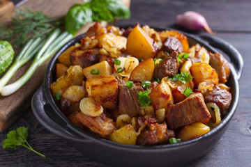 Tasty food: succulent beef with fried potatoes, onion and garlic. Country-style roasted potatoes...
