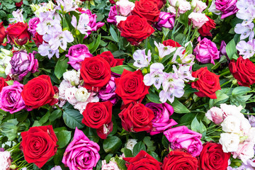 Strauß mit roten und dunkelrosa Rosen mit kleinen Lilien