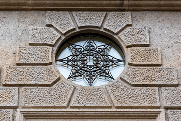 finestra tonda con ornamento in ferro battuto