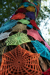 Knitted spider web on a tree.