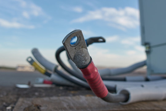 Cables with cable lugs close-up in city street.