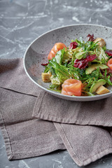 Salmon Salad with spinach, corn salad, baby spinach, fresh mint and basil. Home made food. Concept for a tasty and healthy meal. Dark stone background. Top view. Close up.
