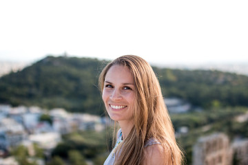 Portrait einer lachenden jungen natürlichen Frau auf der Akropolis in Athen