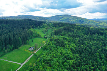 Fototapeta na wymiar Aerial perspective view on sudety mountains during cloudy day with villages in the valley surrounded by meadows and forest