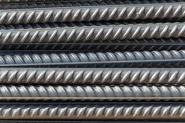 rough iron grunge background: glittering new clean reinforcement bars, short focus