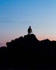 A silhouetted man upon a mountain 