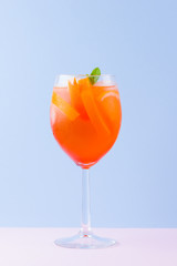 Cocktail Aperol Spritz on a blue pink background. Italian cocktail aperol spritz in pop art style. Summer trendy drink on pastel background