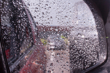 Raindrops on the rearview mirror in the car