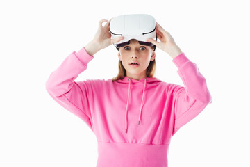 shocked teenage girl in pink hoodie holding vr headset isolated on white