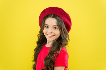 modern fashion style. childhood. hairdresser salon. little girl in french style hat. summer fashion and beauty. parisian child on yellow background. happy girl with long curly hair in beret