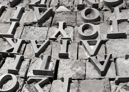 Metal letters of the Greek alphabet on a gray stone surface background.