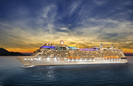 Luxury cruise ship sailing to port on sunset. 