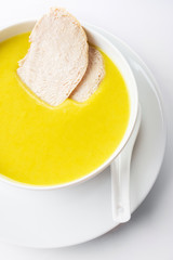 Chicken cream soup with a curry and pieces of chicken meat. On a white background. Close up. Selective focus.