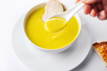 Chicken cream soup with a curry and pieces of chicken meat. On a white background. Toasts with garlic and cheese. Close up. Selective focus.