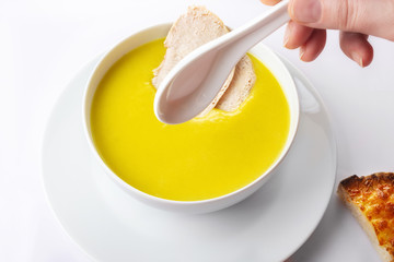 Chicken cream soup with a curry and pieces of chicken meat. On a white background. Toasts with garlic and cheese. Close up. Selective focus.