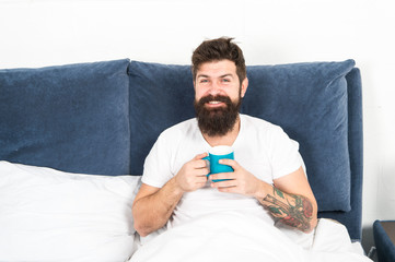 Relax and rest. Humanity runs on coffee. Man brutal handsome hipster relaxing bedroom drink coffee. Bearded guy enjoy morning coffee. Tune in to new day. Morning awakening better with cup coffee