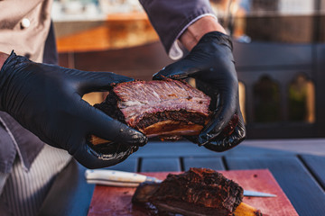 Chef holding cutted juicy slow cooked meat in hands
