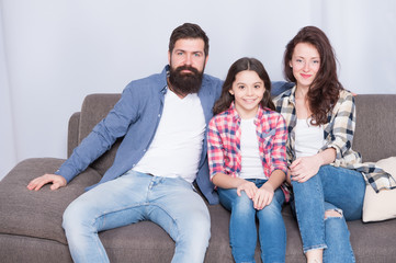 We are family. Family spend weekend together. Friendly family sit couch posing for photo family album. Mom dad and daughter relaxing on couch. Close and trustful relations. Family bonds concept