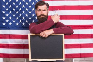 American style. American barber hair stylist or hairdresser american flag background. Man beard and mustache hold scissors and blackboard copy space. 4th of july. Get haircut here. Happy hours