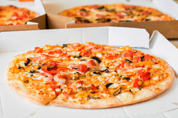 Delicious pizza Margherita with tomatoes and cheese in paper box