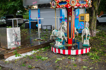 Children's carousel at the Ammersee in Bavaria after a heavy thunderstorm with a hailstorm
