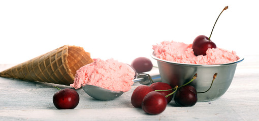 Cherry and vanilla ice cream scoop with fresh cherries and mint on a rustic background