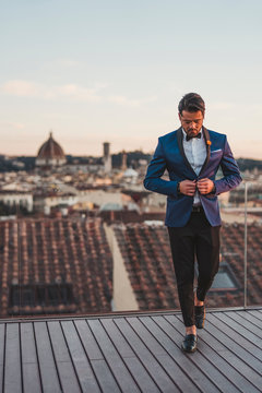 Italy, Florence, stylish man on roof terrace at sunset