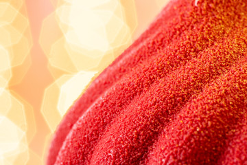 Mini mousse pastry dessert covered with red velour. Garland lamps bokeh on background. Modern...