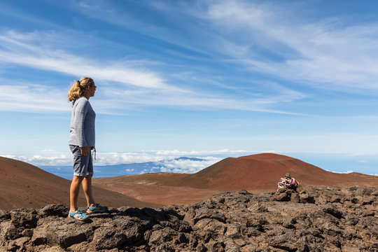 USA, Hawaii, Mauna Kea volcano, female tourist looking at view over volcanic landscape