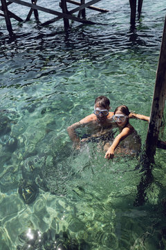 Indonesia, Komodo National Park, father and daughter with diving goggles in the sea