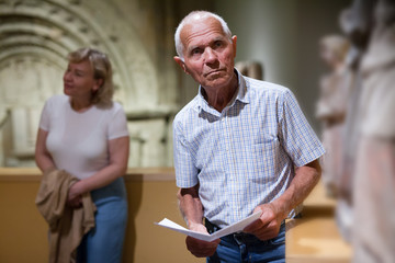Man holding brochure at museum