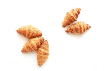 Five freshly baked tasty crusty croissants isolated on white.