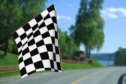 Checkered waving flag on city background. Concept