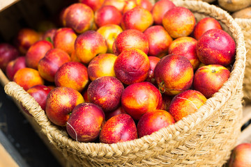 ripe nectarines in wicker baskets on counter